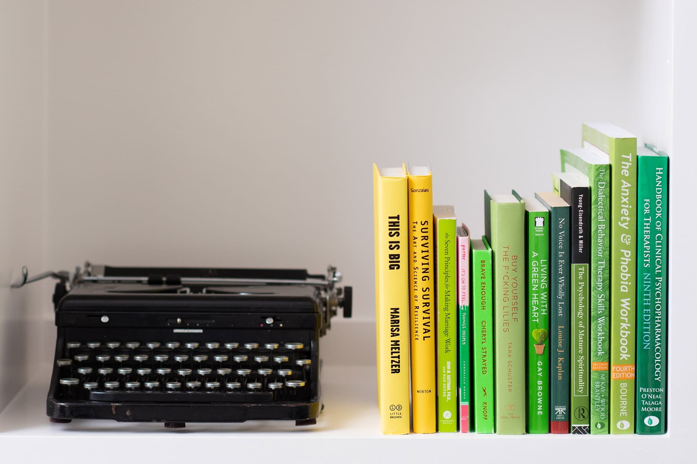 Typewriter next to books on a bookshelf