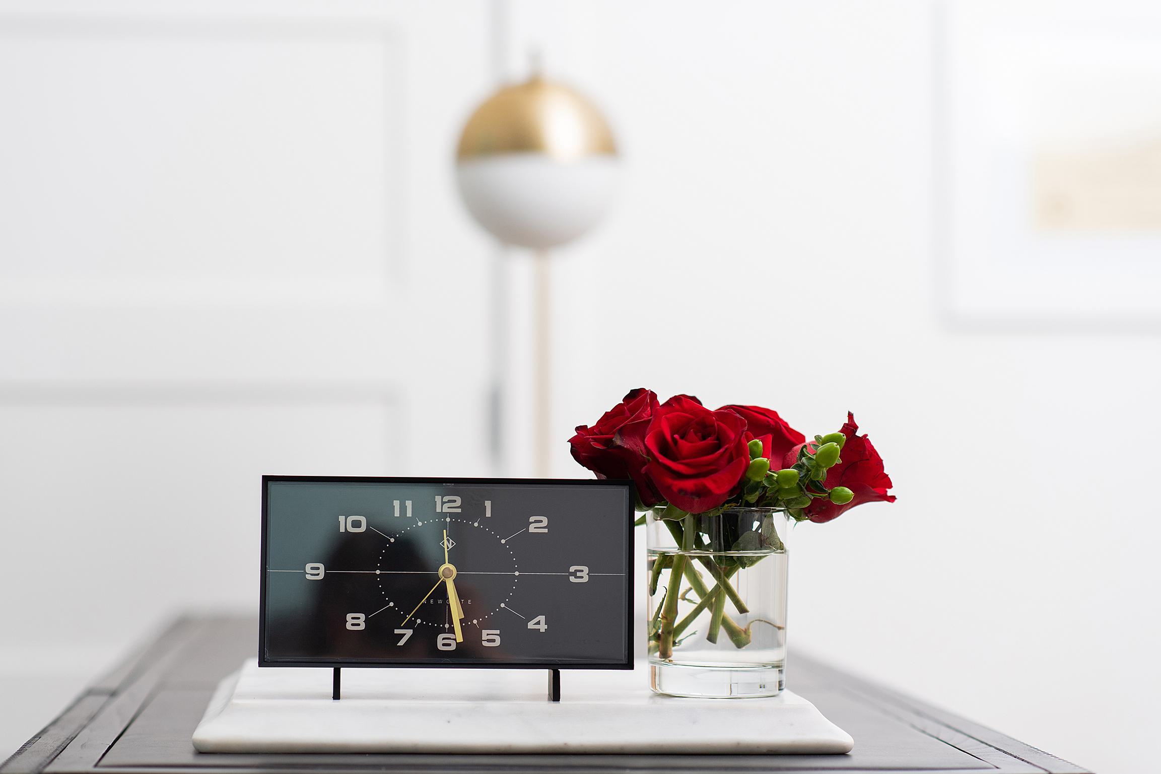 Clock and roses on a table